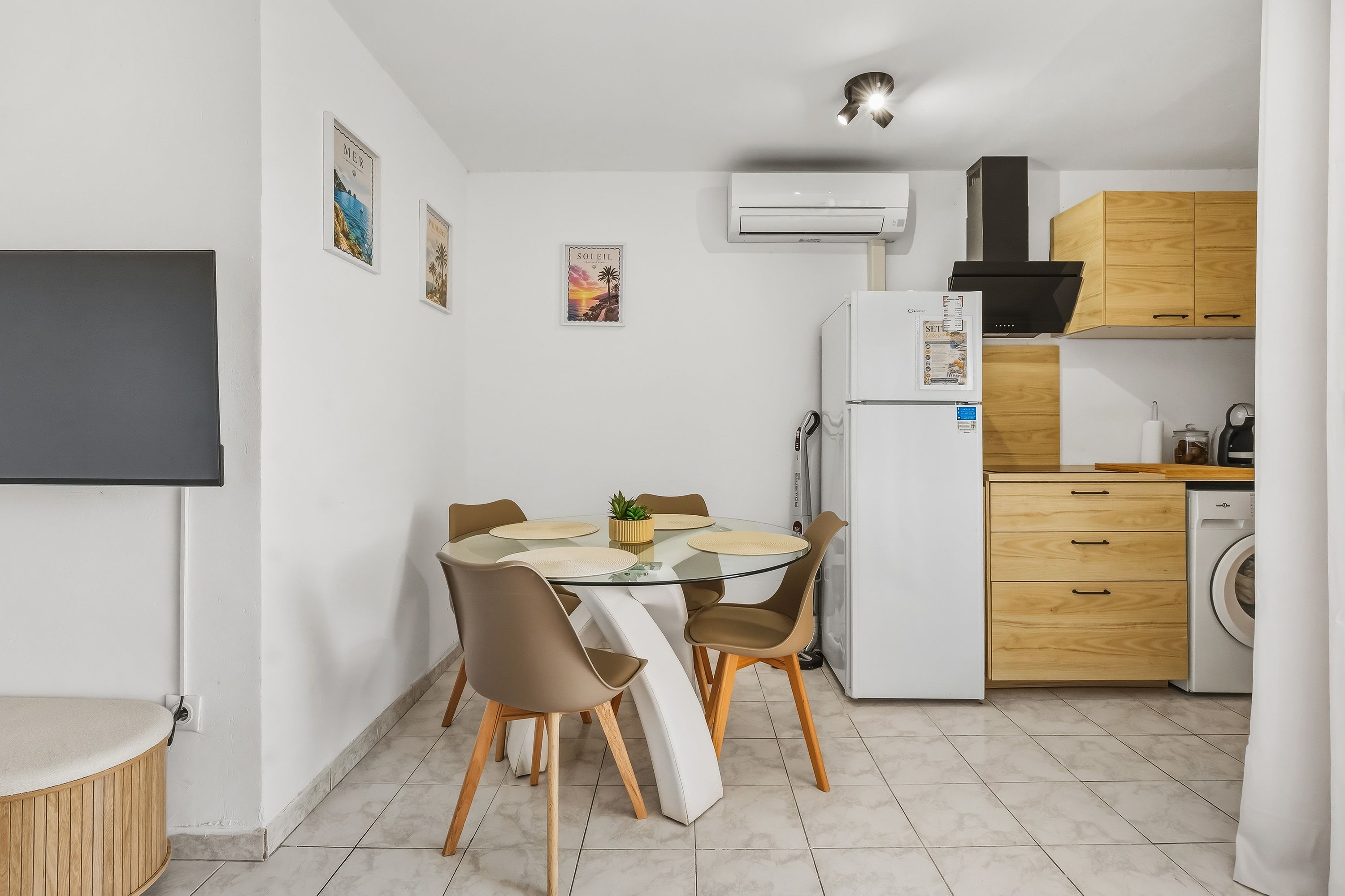 A compact kitchen with a dining area, a built-in oven, and a washing machine.