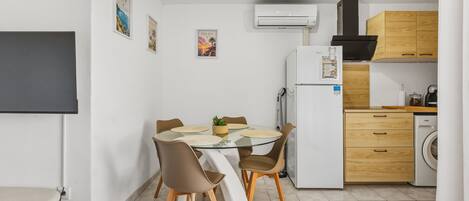 A compact kitchen with a dining area, a built-in oven, and a washing machine.