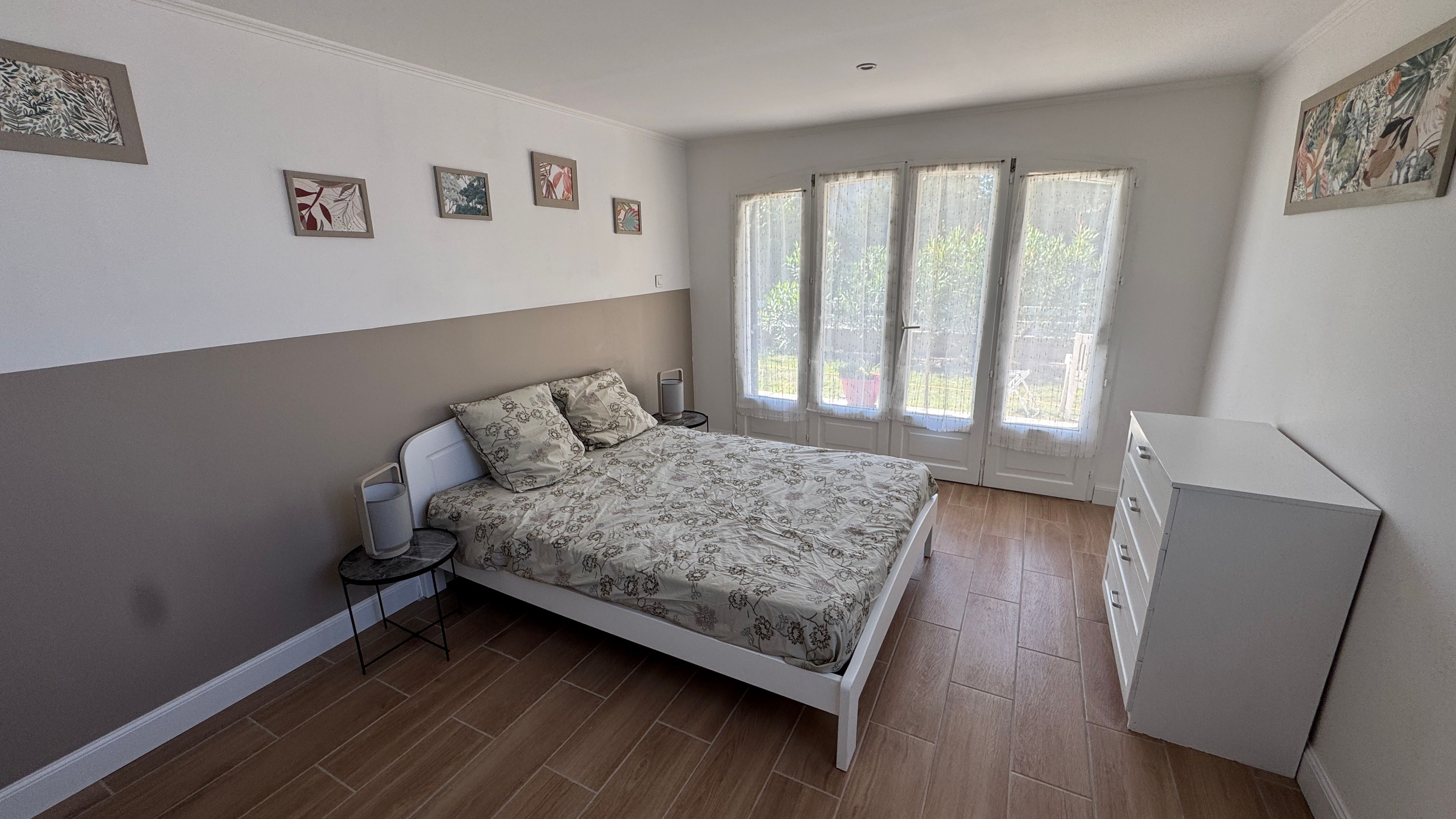 Un dormitorio con cama, mesita de noche, lámpara y cómoda.