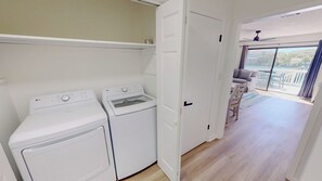 A laundry room with two white washing machines and a door leading to a balcony with a view. - Beautiful Spacious Townhome SBAY 54 (Destin)