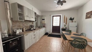 A kitchen with a dining area, a ceiling fan, and a refrigerator. - Serene Ground-floor Apartment With Private Pool in Castilenti (Castilenti)