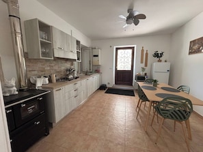 Una cocina con comedor, ventilador de techo y refrigerador.