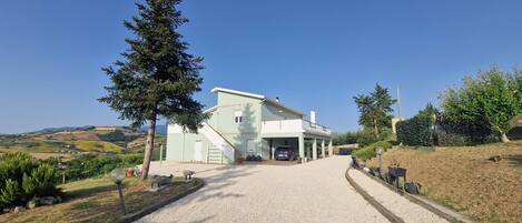 A two-story building with a driveway leading to a garage.