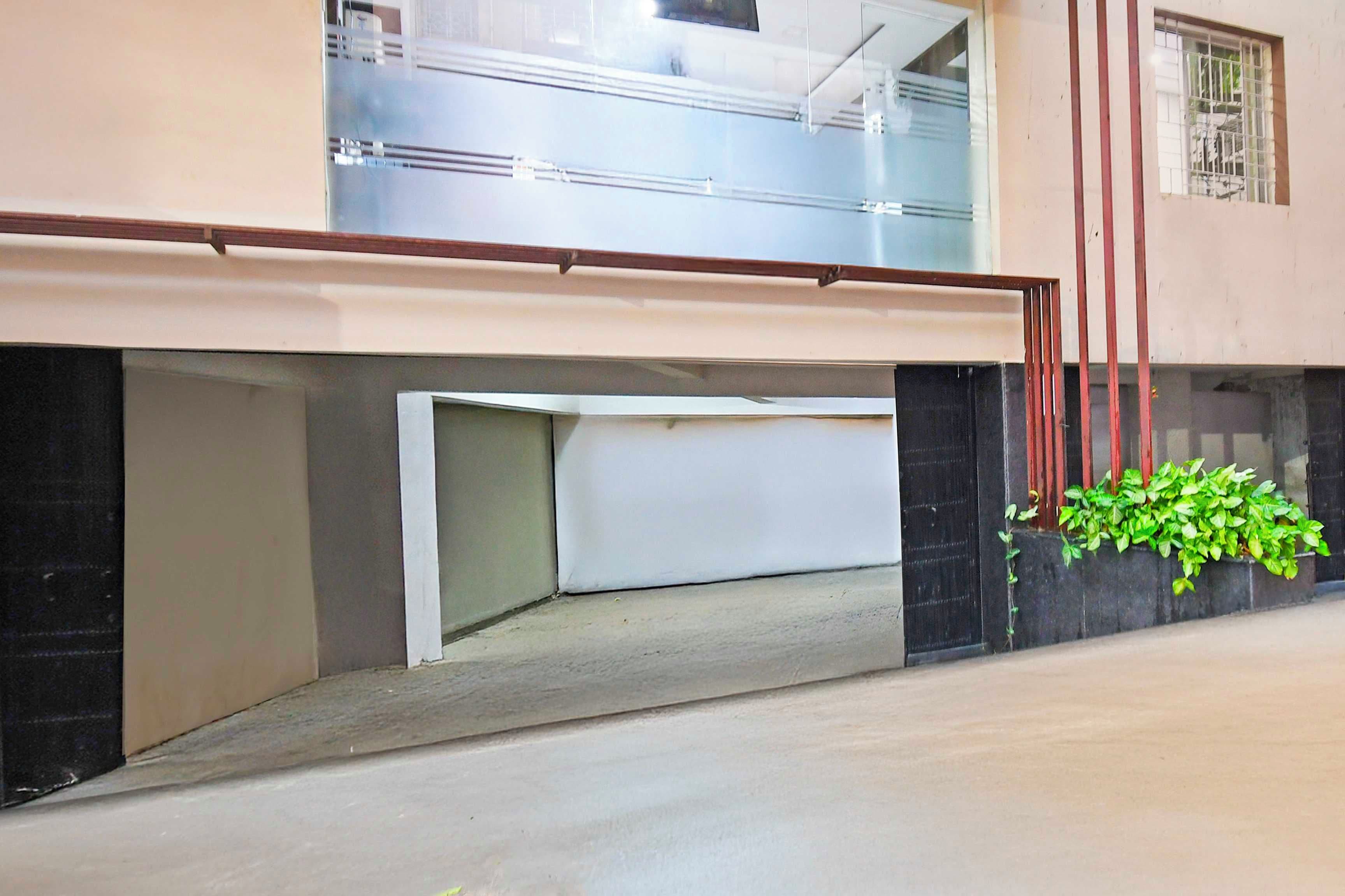 Un edificio con techo plano, una ventana visible y una planta en la pared exterior.