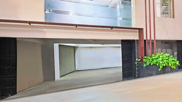 Un edificio con techo plano, una ventana visible y una planta en la pared exterior.