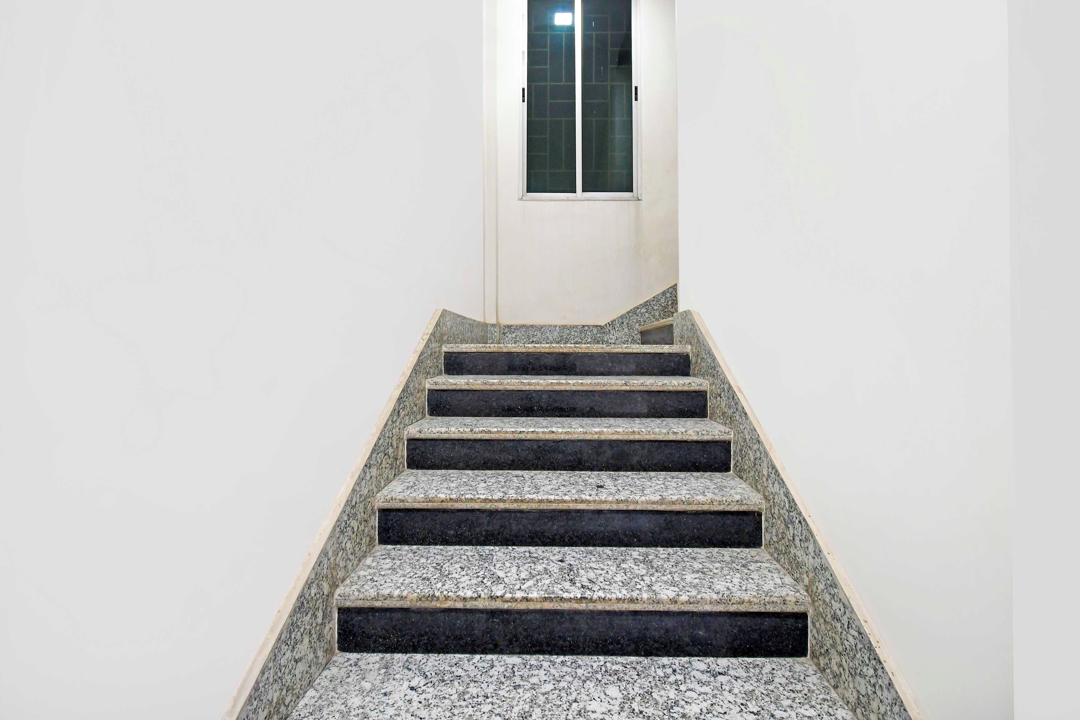 A staircase with a handrail leading to a door with a window.