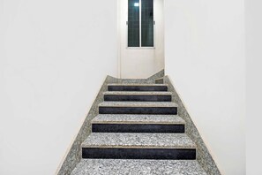 A staircase with a handrail leading to a door with a window. - Townhouse Oak Dhanbad Bhuli Hirak Road (Dhanbad)