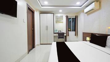A hotel room with a bed, a desk, a chair, and a wardrobe.