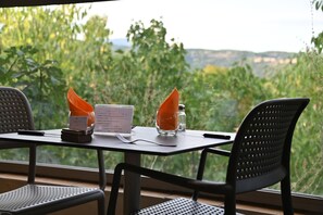A table set for two with a menu, a glass of orange juice, and a salt shaker.