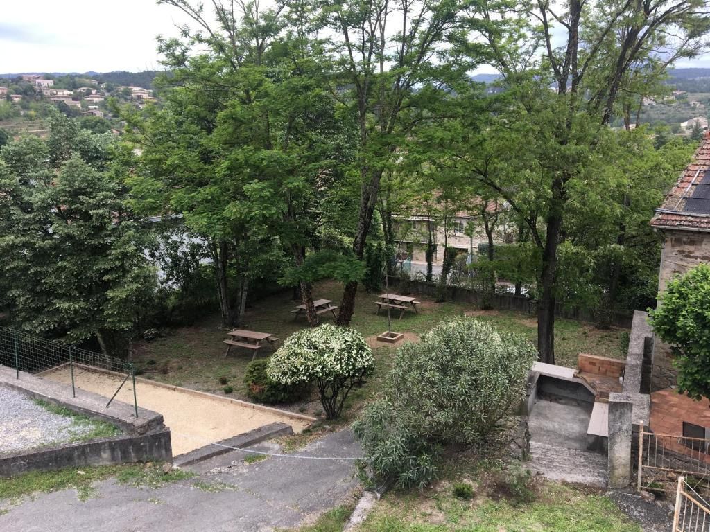 Un patio con árboles, una zona de barbacoa y vistas a un pueblo lejano.