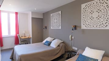 Una habitación de hotel con cama, mesitas de noche, escritorio y paneles decorativos en la pared.