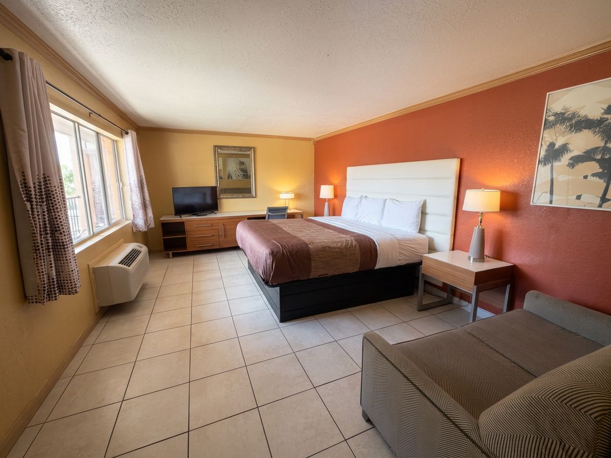 Una habitación de hotel con dos camas, televisión, escritorio y silla.