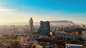 A cityscape with various buildings, including a prominent tower and a modern structure. - Résidence Jasmins  (Oran)