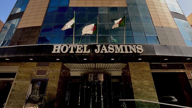 A modern hotel with a prominent entrance and a name sign. - Résidence Jasmins  (Oran)