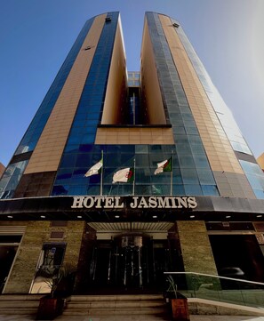 A modern hotel with a prominent entrance and a name sign.