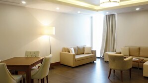 A modern living room with a dining table, two sofas, and a floor lamp. - Résidence Jasmins  (Oran)