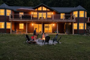 A two-story lodge with a deck, outdoor seating, and a fire pit. - Whiteface Getaway | Fire Pit, Game Room, Bunk Room (Jay)