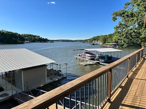 Ein Ufergrundstück mit Anlegesteg, überdachtem Bootsheim und einer Holzterrasse.