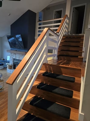 Eine Treppe mit Holzboden und weißen Geländern, die zu einer oberen Ebene führt.