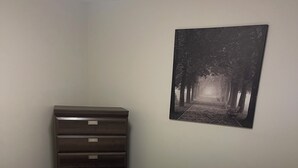 A bedroom with a bed, a dresser, and a wall-mounted picture. - Adorable 1-bedroom condo in beautiful Calgary perfect for your stay (Calgary)