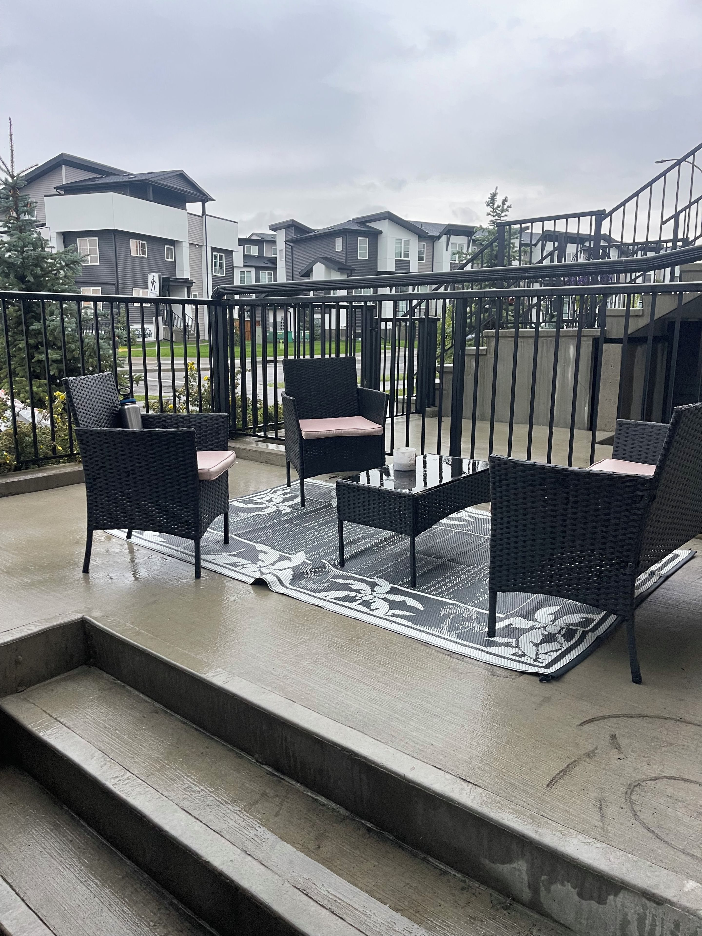 Ein Balkon mit Gartenmöbeln und Blick auf Wohnhäuser.