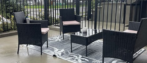 A balcony with outdoor furniture and a view of residential buildings.