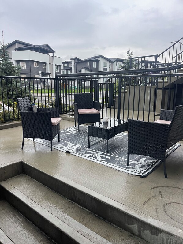Un balcon aménagé avec du mobilier d’extérieur et offrant une vue sur des immeubles d’habitation.