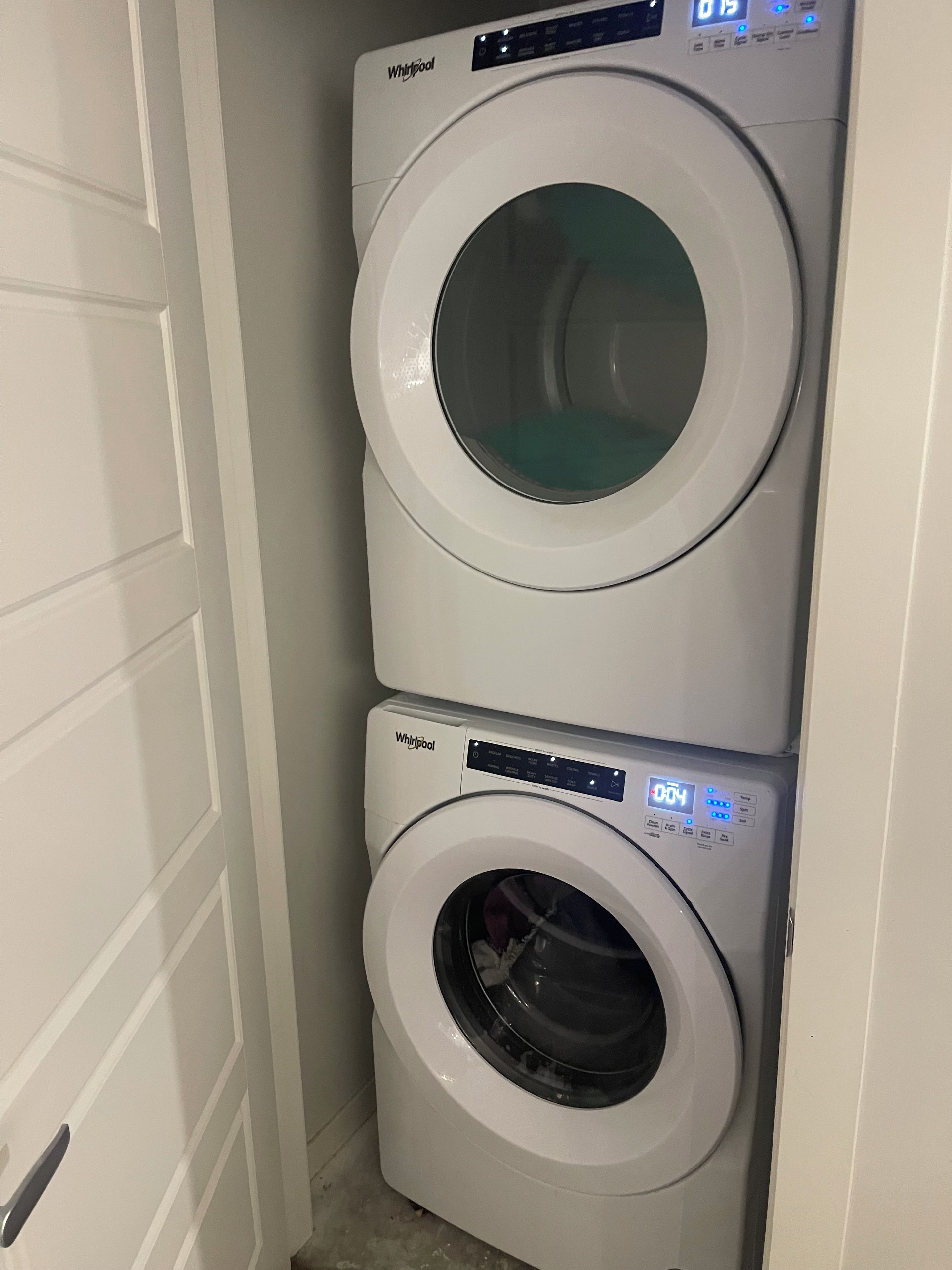Une machine à laver et un sèche-linge superposés dans une buanderie.