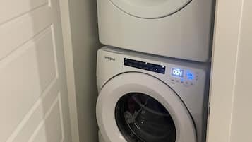 Une machine à laver et un sèche-linge superposés dans une buanderie.
