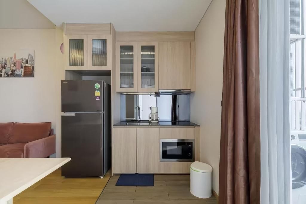A compact kitchen with a refrigerator, microwave, and coffee maker.