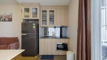 A compact kitchen with a refrigerator, microwave, and coffee maker.