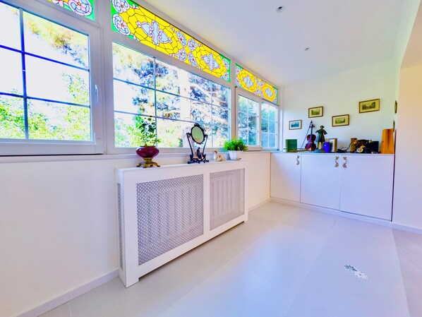 A room with large windows, a radiator, and decorative items on the windowsill.