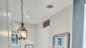 Une salle de bain moderne avec une baignoire sur pieds, un meuble-lavabo avec miroir et un luminaire suspendu.