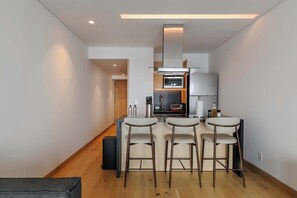 A modern kitchen with a central island, bar stools, and a built-in oven. - w* | Enchanting Loft in Juarez w/ Pool (Ciudad de México)