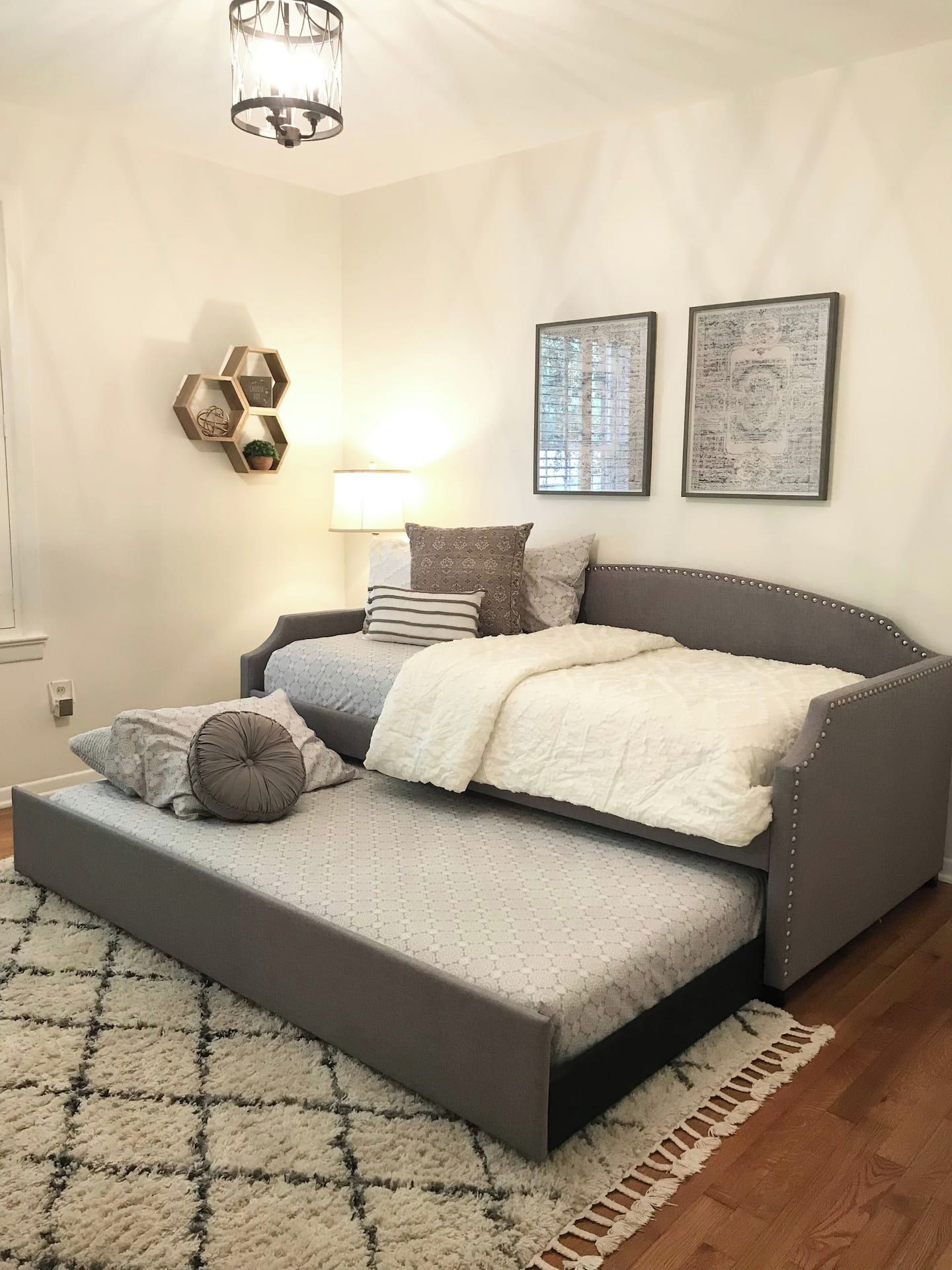 A bedroom with a bed, a bedside table, a lamp, and wall decorations.