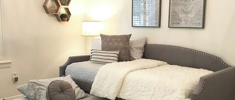 A bedroom with a bed, a bedside table, a lamp, and wall decorations.