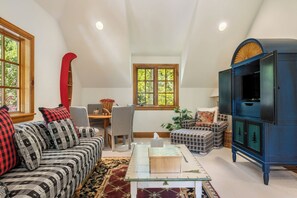 A cozy living room with a high ceiling, a fireplace, a television, and a dining area with a table and chairs. - Newly Listed! 8BR Beaver Creek Home | Hot Tub (Avon)