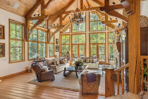 A spacious room with large windows, wooden beams, and a chandelier. - Newly Listed! 8BR Beaver Creek Home | Hot Tub (Avon)