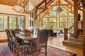 A spacious dining area with a large wooden table, multiple chairs, and a chandelier. - Newly Listed! 8BR Beaver Creek Home | Hot Tub (Avon)