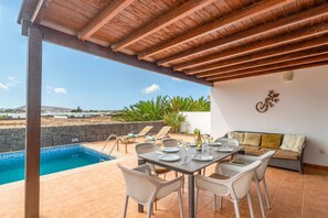 Eine Außenpatio mit Pool, Essbereich und Sitzgelegenheiten.