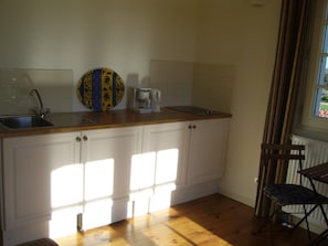 A kitchen with a wooden countertop, a coffee maker, and a decorative plate. - Holiday Home 'La Source' with WiFi and Pyrenees View (Puymaurin)