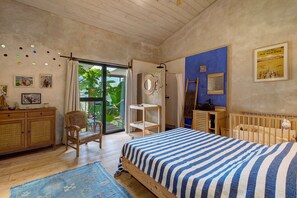 Une chambre à coucher comprenant un lit, une chaise, une armoire en bois, une étagère et une fenêtre donnant sur un paysage verdoyant.