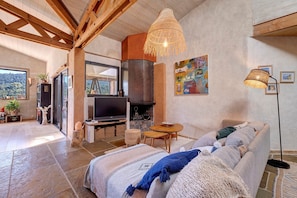 A spacious living room with a fireplace, a television, and a dining area. - Villa 'Sawubona' with Mountain View, Private Terrace and Wi-Fi (Les Adrets-de-l'Estérel)
