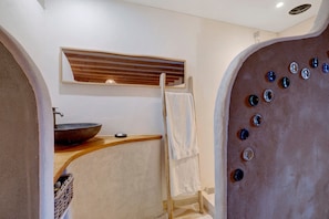 Une salle de bain avec un meuble-lavabo en bois, un évier, un porte-serviettes et un miroir.