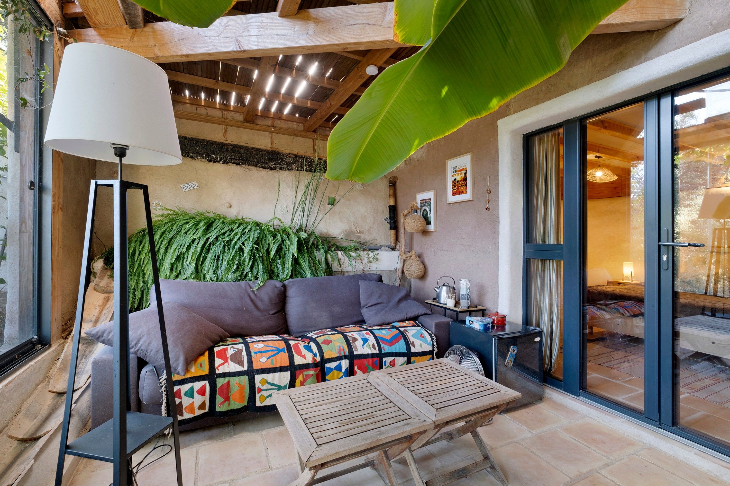 Een gezellig interieur met een bank, een tafel en een grote plant.
