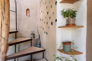 A staircase with a rustic wooden finish, a wall with circular cutouts, and potted plants on shelves. - Bed and Breakfast 'Marsaou' with Mountain View, Shared Terrace and Wi-Fi (Les Adrets-de-l'Estérel)