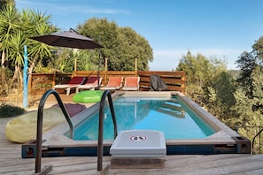 A swimming pool with a wooden deck, lounge chairs, and a covered area with an umbrella. - Bed and Breakfast 'Marsaou' with Mountain View, Shared Terrace and Wi-Fi (Les Adrets-de-l'Estérel)