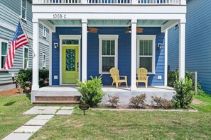 A residential house with a green door, two Adirondack chairs on the porch, and a small sign indicating resident parking. - Downtown Port Royal Roost (Port Royal)