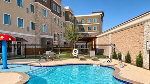 A swimming pool with a lifeguard chair, lounge chairs, and a covered seating area. - Accessible 1-Bdrm Suite | Free Breakfast & Pool (The Colony)