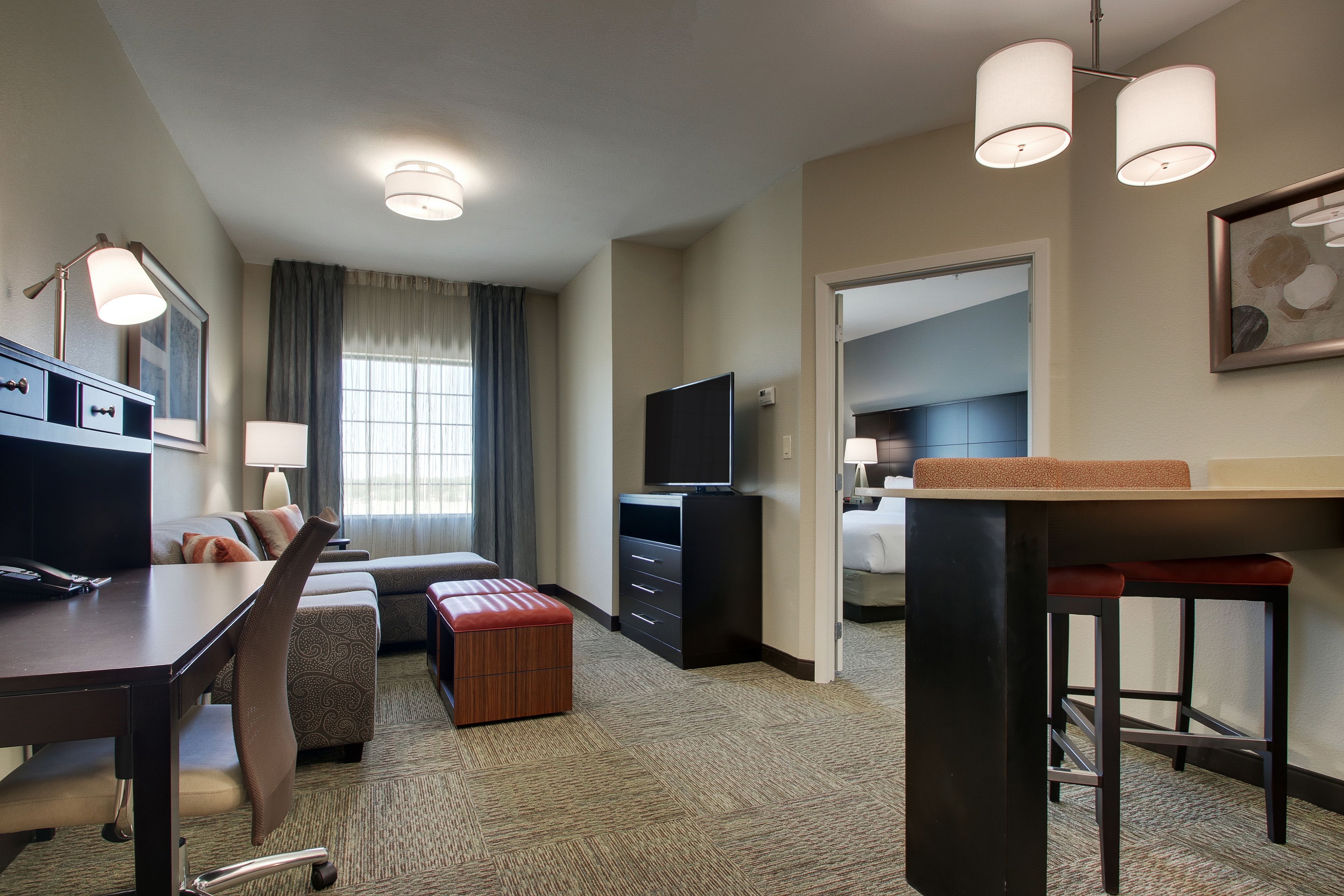 Une chambre d’hôtel comprenant un coin repas, une télévision, un bureau et un lit.